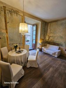 een woonkamer met een tafel en stoelen en een kroonluchter bij Appartamento Signoria in Florence