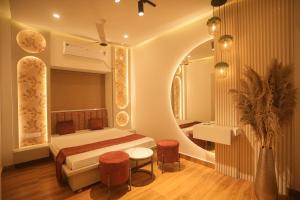 a bedroom with a bed and stools in a room at Meghnad By Padmaraag in Nalbāri
