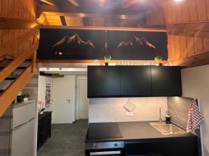 a kitchen with a sink and a counter top at Dinastia Case Snow Apartment in Passo del Tonale