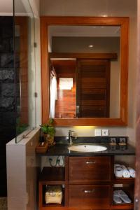 een badkamer met een wastafel en een spiegel bij Lebak Bali Residence in Canggu +33 foto's