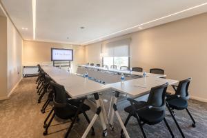 a conference room with tables and chairs and a screen at Citadines Almaz Aparthotel Casablanca in Casablanca