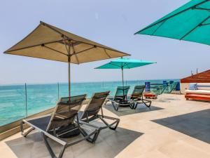 a group of chairs and umbrellas on the beach at Illy - Ocean by Coralia - 4 Px in Taghazout