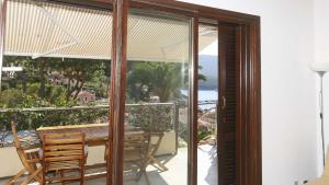 een terras met een tafel en stoelen op een balkon bij Il Porto 13 - Goelba in Porto Azzurro