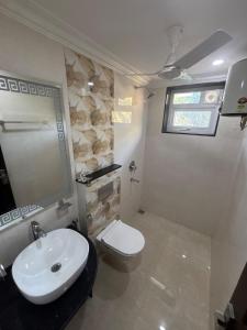 ein Badezimmer mit einem weißen Waschbecken und einer Toilette in der Unterkunft Monstera-Kudrat's Nilaya in Canacona