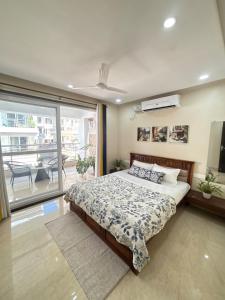 ein Schlafzimmer mit einem großen Bett und einem Balkon in der Unterkunft Monstera-Kudrat's Nilaya in Canacona