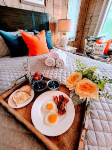 a tray with two plates of breakfast food on a bed at Lakefront Hot Tub Canoes Game Room Wood FP in Gouldsboro