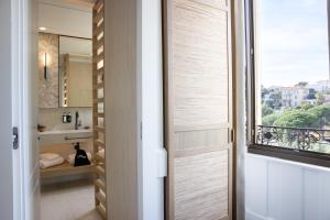 a bathroom with a sliding door with a window at Hotel Royal-Riviera in Saint-Jean-Cap-Ferrat