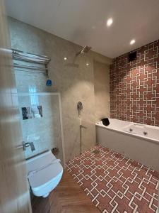 ein Badezimmer mit einer Dusche, einem WC und einer Badewanne in der Unterkunft Hotel Imperial Suites in Navi Mumbai