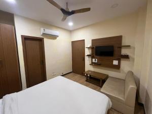 una camera d'albergo con un letto e una TV a schermo piatto di Hotel LAVENIR a Rohtak Altre 7 foto