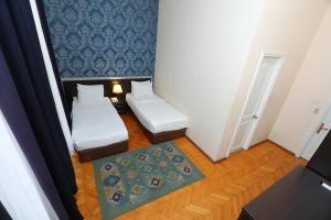 ein kleines Zimmer mit zwei Betten und einem Teppich in der Unterkunft Azcot Hotel in Baku