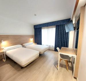 Hotel Costa Atlántica في أرتيكسو: غرفة فندق بها سريران وطاولة