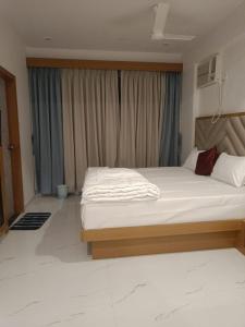 Un dormitorio con una cama grande frente a una ventana. en The Lions Hotel, en Badlapur