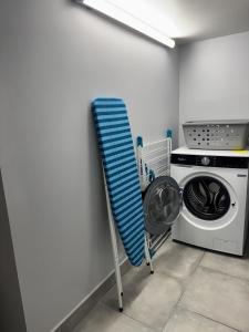 un séchoir à côté d'une machine à laver dans une pièce dans l'établissement Gîte des Prés, à Revin