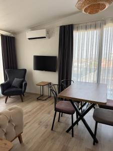 a living room with a table and chairs and a television at aden suits teras in Fethiye +10 photos