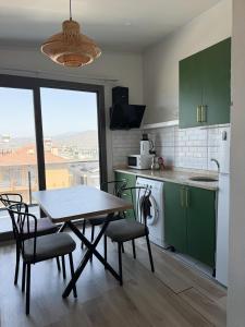 a kitchen with green cabinets and a table and chairs at aden suits teras in Fethiye