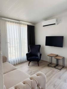 un soggiorno con divano, sedia e TV di aden suits teras a Fethiye