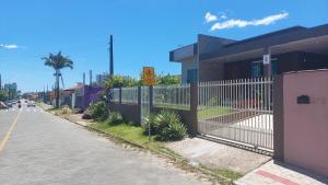 a fence on the side of a street next to a building at Casa Alegre Beach House in Penha