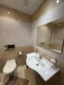 ein Badezimmer mit einem weißen Waschbecken und einer Toilette in der Unterkunft PM Services Royal Plaza Apartments in Borowez + 44 Fotos