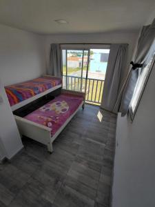 Un dormitorio con una litera y un balcón. en Libertad, Paz, Armonia, en Camet Norte