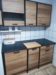eine Küche mit einer schwarzen Theke und Holzschränken in der Unterkunft Apartament in Psary Małe