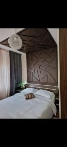 a bedroom with a large white bed with a wooden headboard at Bondar Residence in Galaţi