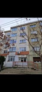 an apartment building with a red fence in front of it at Bondar Residence in Galaţi