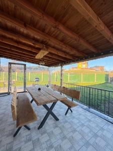 ein großer Holztisch und Stühle auf einer Terrasse in der Unterkunft Къща за гости Пегас in Welingrad