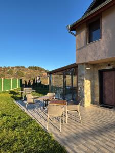 eine Terrasse mit Stühlen und einem Tisch auf einem Haus in der Unterkunft Къща за гости Пегас in Welingrad