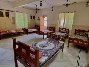 a room with several beds and chairs in it at sandstone Villa jaisalmer in Jaisalmer +1 photo