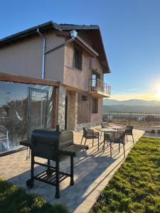 a house with a barbecue grill on a patio at Къща за гости Пегас in Velingrad