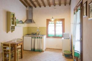 a kitchen with a sink and a table and a window at Casetta di Pietra by ElbaSummer in Marciana