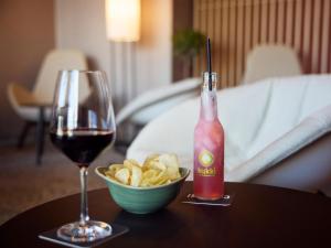 Una copa de vino y un bol de patatas fritas en una mesa en B&B HOTEL Mittenwald, en Mittenwald
