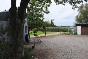 un rimorchio è parcheggiato accanto a un albero di Idyllic Countryside Farm with Horseback Riding a Borup