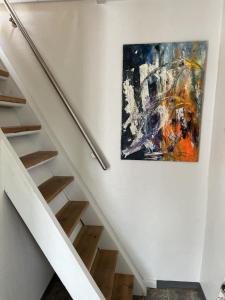 un dipinto appeso a un muro accanto a una scala di Idyllic Countryside Farm with Horseback Riding a Borup