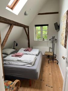 una camera da letto con un letto e una sedia di Idyllic Countryside Farm with Horseback Riding a Borup