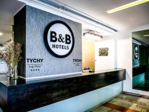 a hotel lobby with a large sign on the wall at B&B HOTEL Tychy in Tychy