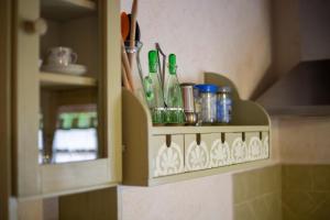 a shelf with cups and utensils on a wall at Casetta di Pietra by ElbaSummer in Marciana