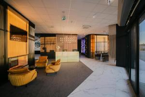 a lobby with couches and chairs in a building at B&B HOTEL Warsaw East in Warsaw