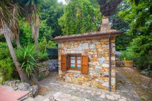 a small stone building with a chimney on top at Casetta di Pietra by ElbaSummer in Marciana