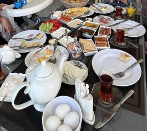 een tafel met borden vol eten, een theepot en eieren bij Garden Sheki Hotel in Sheki