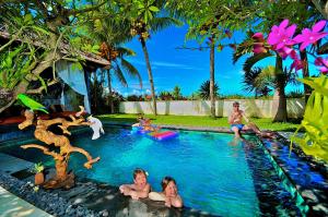 a group of children playing in a swimming pool at The Zala Villa in Canggu