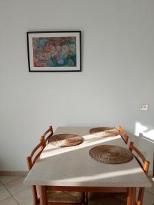 a table with four chairs and a picture on the wall at Casa loto in Pantigliate