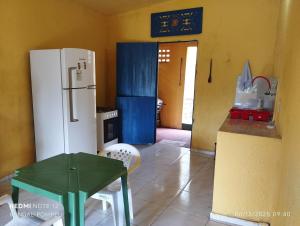 a kitchen with a refrigerator and a table in it at Chalé nas nuvens in Meruoca