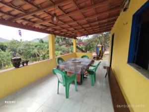 a table and chairs on the balcony of a house at Chalé nas nuvens in Meruoca