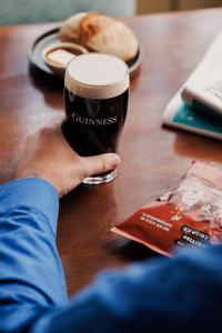 a person holding a glass of beer on a table at Bear and Ragged Staff in Oxford