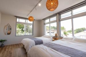 two beds in a bedroom with large windows at 栞-shiori-FUNAKURA in Ishigaki Island