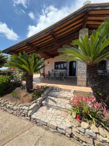 a house with two palm trees and a patio at Villa La Giulia in Cerveteri