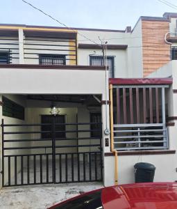 un coche aparcado frente a un edificio con garaje en Teves Suite Lipa City, en Lipá