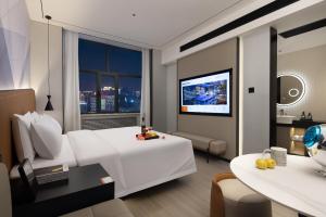 ein Hotelzimmer mit Bett und Fernseher in der Unterkunft Huanzhi Hotel Hulunbuir Hailar Railway Station Branch in Hulunber + 10 Fotos