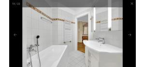 een witte badkamer met een bad, een wastafel en een bad bij Ferienwohnung in Bad Saarow in Bad Saarow +12 foto's